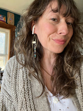 Load image into Gallery viewer, Anita Fontaine wearing her long brass beaded earrings in her home studio